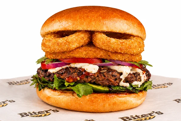 Gourmet burger with crispy onion rings, beef patty, lettuce and tomat